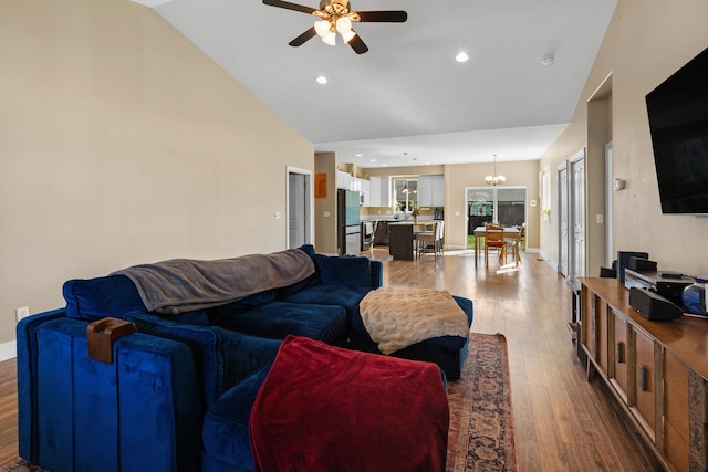 living area with recessed lighting, baseboards, wood finished floors, and ceiling fan with notable chandelier
