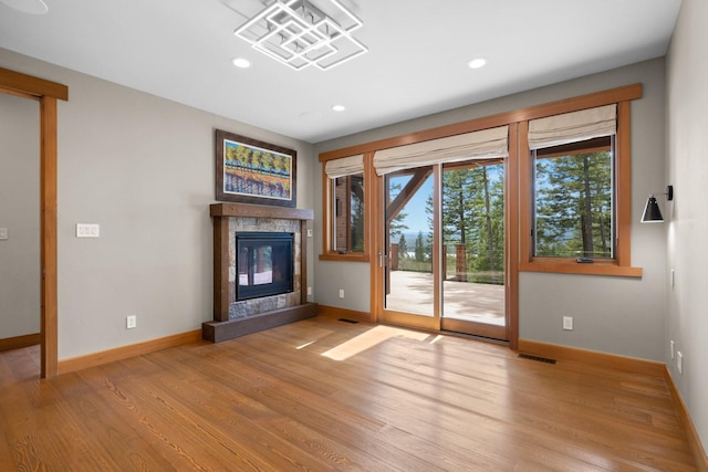 unfurnished living room with baseboards, recessed lighting, a stone fireplace, and visible vents
