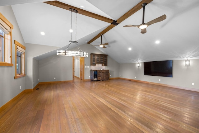unfurnished living room with a ceiling fan, baseboards, lofted ceiling with beams, and light wood-type flooring