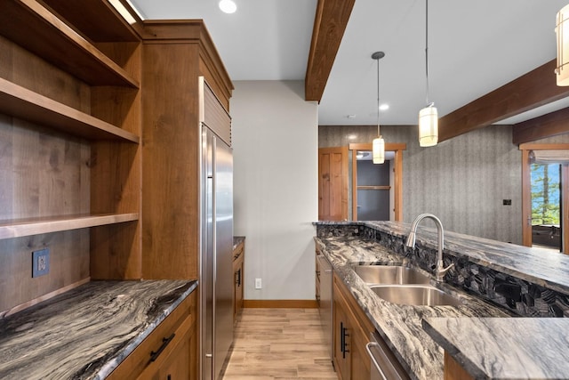 kitchen featuring brown cabinetry, open shelves, beam ceiling, a sink, and light wood finished floors