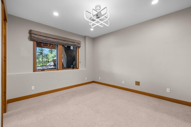 spare room featuring carpet floors, recessed lighting, and baseboards