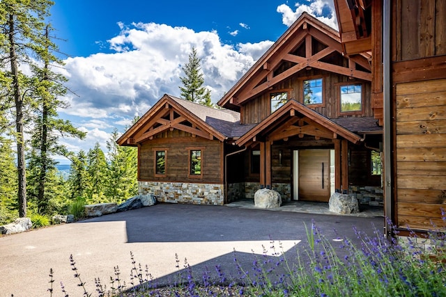 log home featuring stone siding