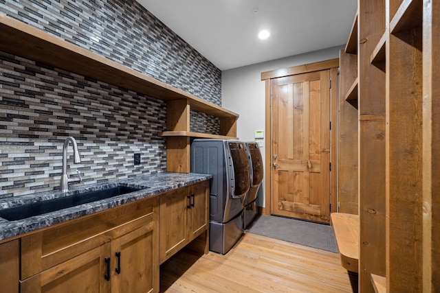 laundry area with a sink, separate washer and dryer, and light wood finished floors
