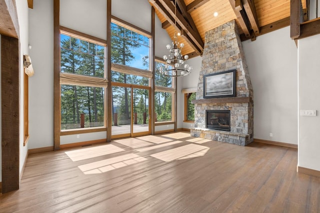 unfurnished living room with high vaulted ceiling, plenty of natural light, and baseboards