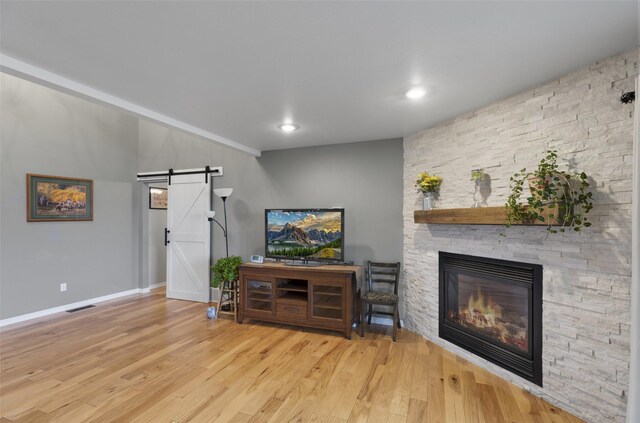 208 40th Ave NE, Great Falls, MT 59404 - living area featuring visible vents, wood finished floors, a fireplace, baseboards, and a barn door
