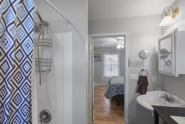 208 40th Ave NE, Great Falls, MT 59404 - full bath with a ceiling fan, wood finished floors, curtained shower, a textured ceiling, and a sink