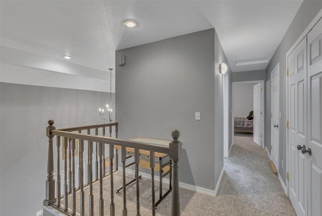 208 40th Ave NE, Great Falls, MT 59404 - hallway featuring baseboards, carpet, a notable chandelier, and an upstairs landing