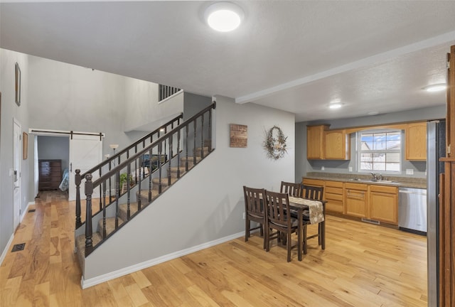 208 40th Ave NE, Great Falls, MT 59404 - dining space with stairs, visible vents, a barn door, and light wood-type flooring