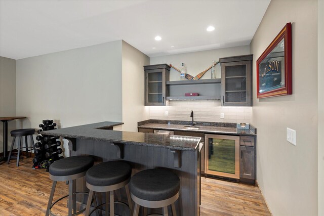 14 Marina Crest Ln, Whitefish, MT 59937 - bar with beverage cooler, light wood-style flooring, wet bar, and backsplash