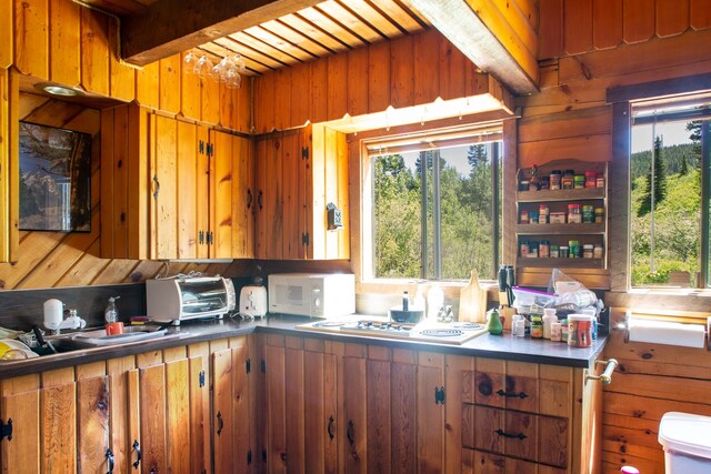 kitchen featuring wooden walls, brown cabinetry, and white appliances