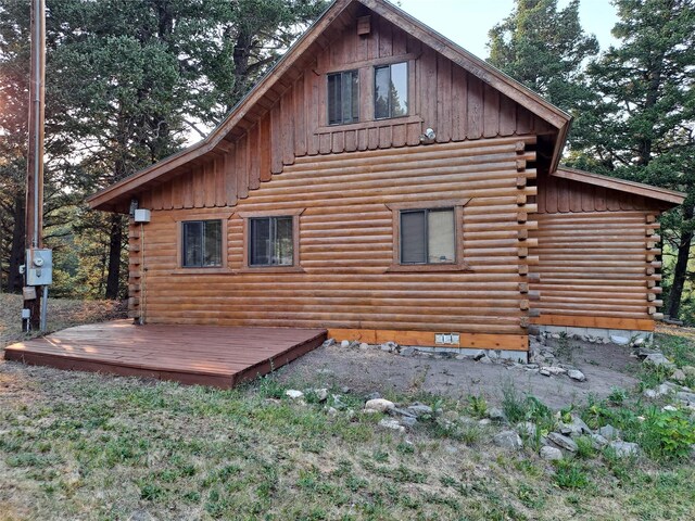 rear view of house featuring log siding, board and batten siding, and a deck