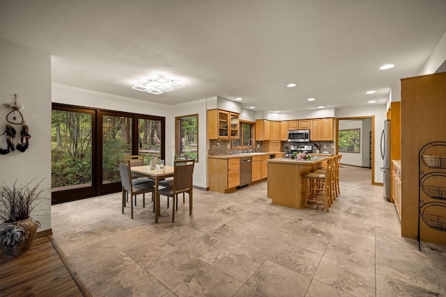 kitchen featuring a center island, light countertops, a sink, stainless steel appliances, and recessed lighting