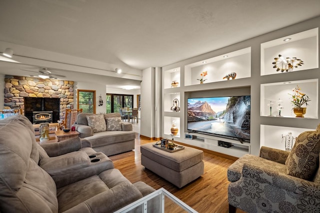 cinema with baseboards, a ceiling fan, wood finished floors, and a fireplace