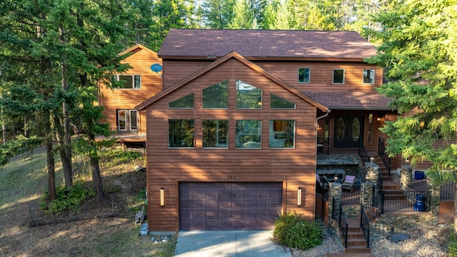 rustic home featuring a garage and concrete driveway