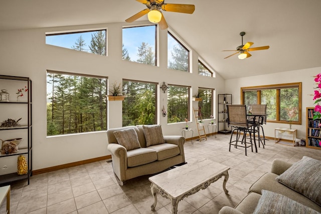 tiled living room featuring a healthy amount of sunlight, high vaulted ceiling, and ceiling fan