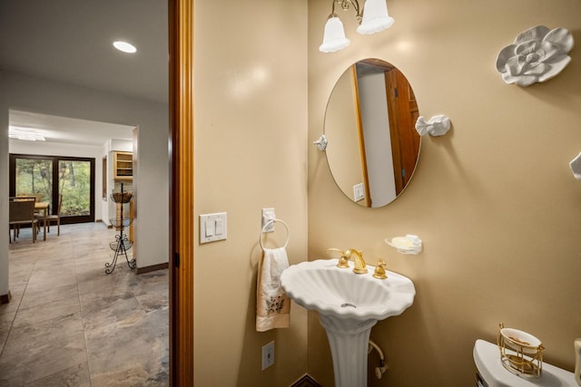 bathroom with baseboards, recessed lighting, and toilet