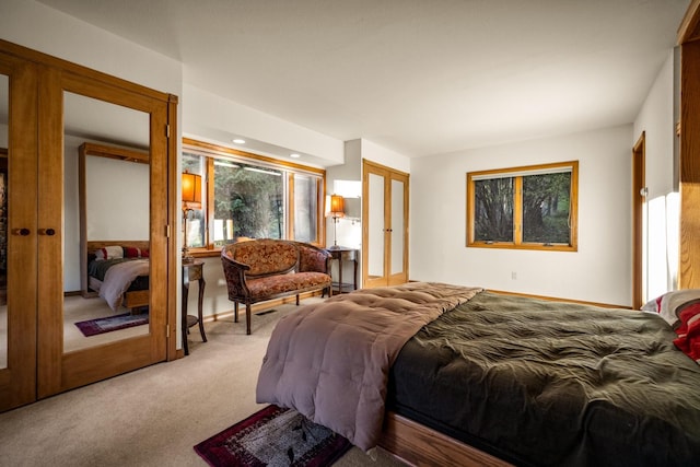 bedroom featuring french doors and light colored carpet
