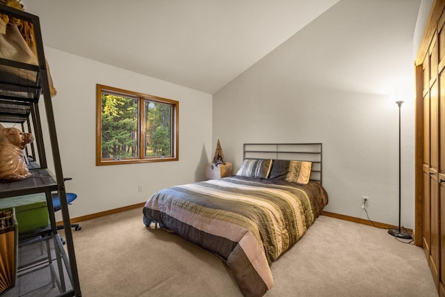 bedroom with baseboards, lofted ceiling, and carpet