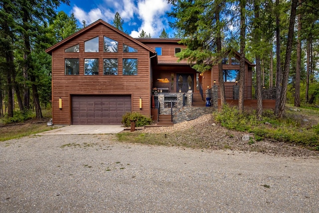 view of front of property featuring a porch, an attached garage, and driveway