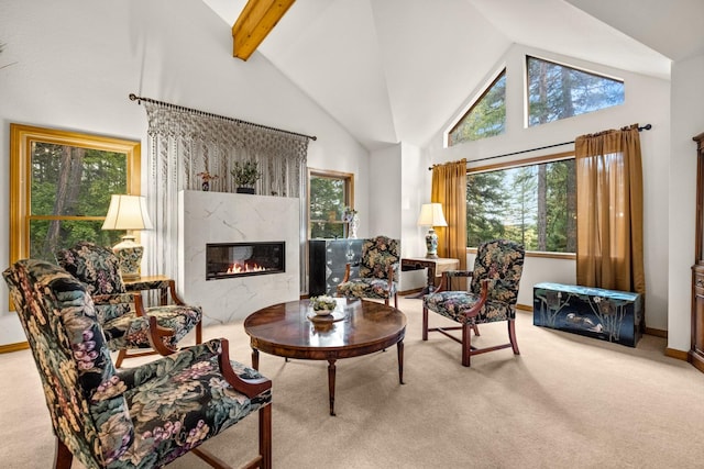 living area with a high end fireplace, carpet floors, high vaulted ceiling, and a healthy amount of sunlight