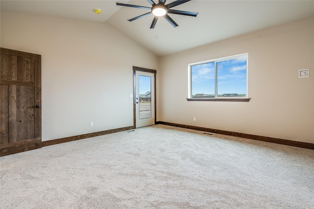 carpeted empty room featuring baseboards, ceiling fan, and vaulted ceiling