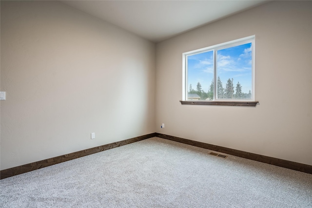 empty room featuring carpet floors, baseboards, and visible vents