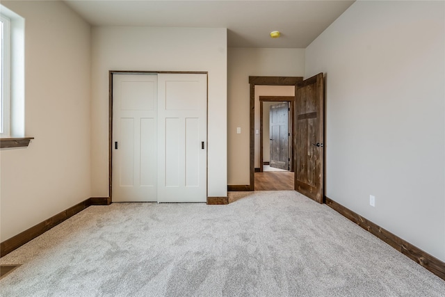 unfurnished bedroom featuring a closet, carpet, and baseboards