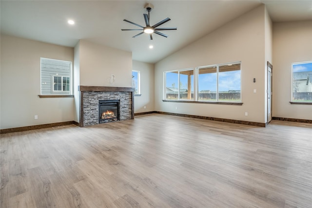 unfurnished living room with light wood-style floors, baseboards, ceiling fan, and a fireplace
