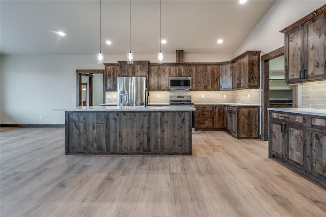 kitchen with backsplash, dark brown cabinets, and appliances with stainless steel finishes