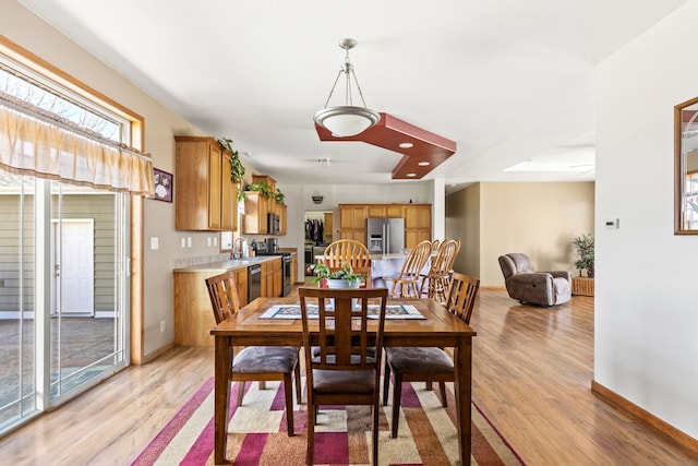 dining area with light wood-style floors and baseboards