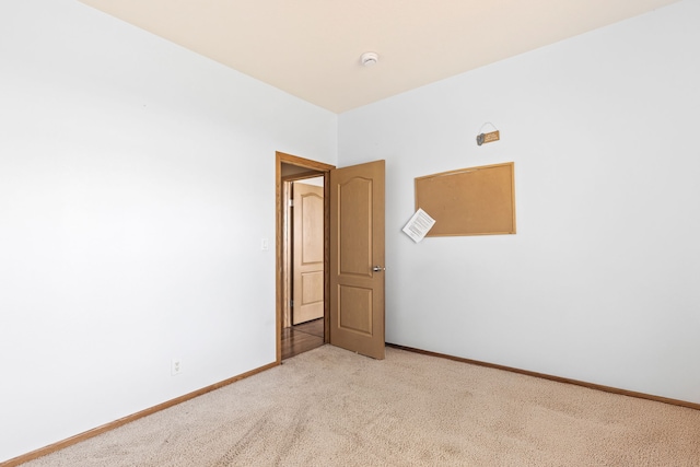 spare room with baseboards, visible vents, and light colored carpet