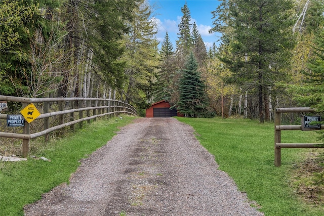 view of street with a view of trees and driveway