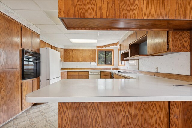 535 Reservoir Rd, Whitefish, MT 59937 - kitchen featuring light countertops, a peninsula, light floors, a drop ceiling, and white appliances