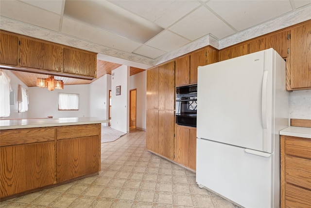 535 Reservoir Rd, Whitefish, MT 59937 - kitchen featuring brown cabinetry, freestanding refrigerator, oven, light floors, and light countertops