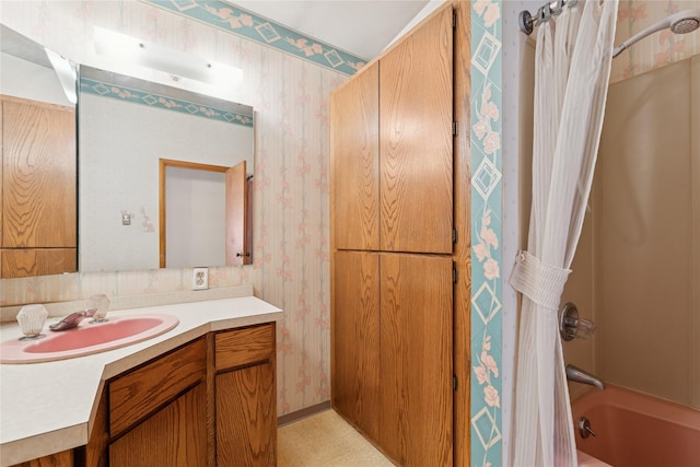 bathroom featuring shower / bath combo with shower curtain, wallpapered walls, and vanity