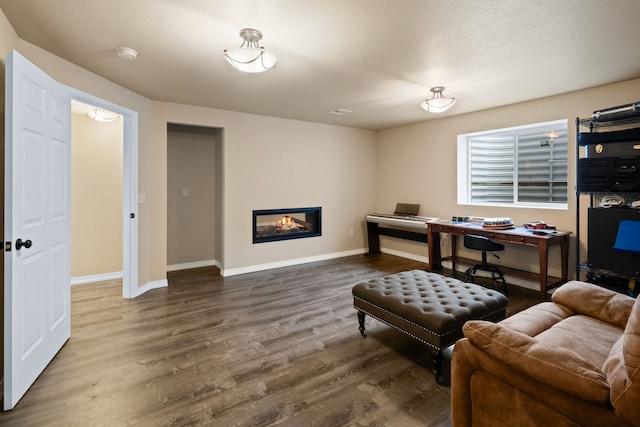 4217 Bordeaux Blvd, Missoula, MT 59808 - home office featuring a glass covered fireplace, baseboards, and dark wood-style floors