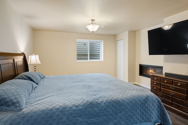 4217 Bordeaux Blvd, Missoula, MT 59808 - bedroom featuring a glass covered fireplace, baseboards, and wood finished floors