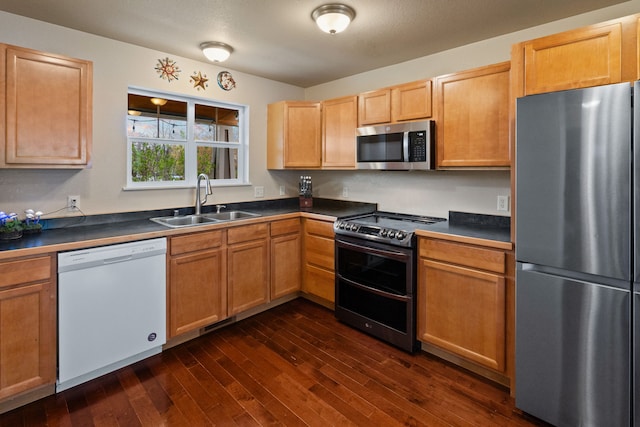 4217 Bordeaux Blvd, Missoula, MT 59808 - kitchen with dark countertops, appliances with stainless steel finishes, a sink, and dark wood finished floors