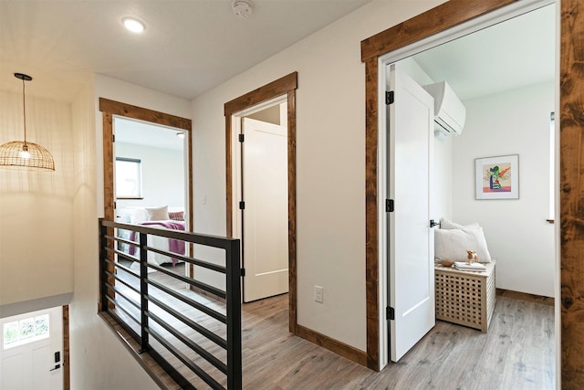 hallway featuring plenty of natural light, wood finished floors, and a wall mounted air conditioner