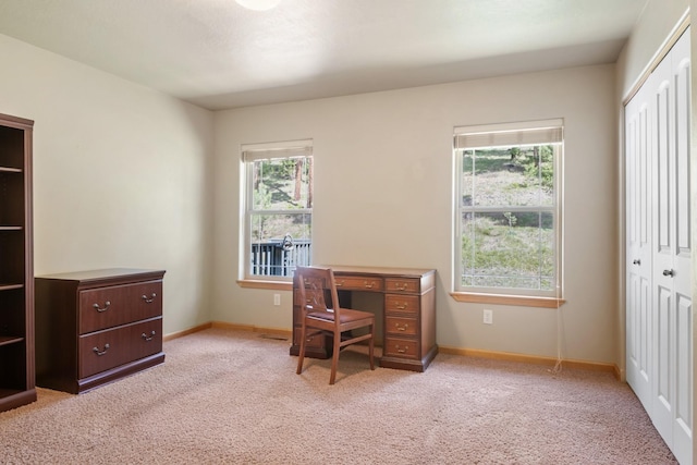 home office featuring baseboards, light colored carpet, and a healthy amount of sunlight