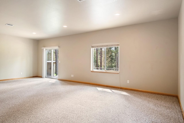 spare room with light colored carpet, recessed lighting, baseboards, and visible vents