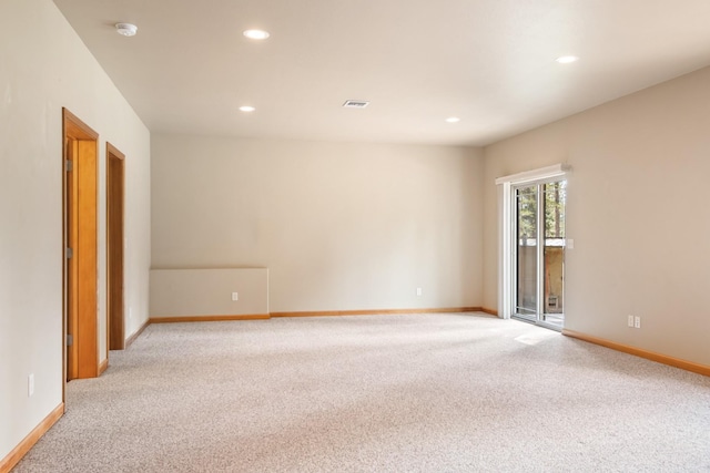 empty room featuring recessed lighting, baseboards, light colored carpet, and visible vents