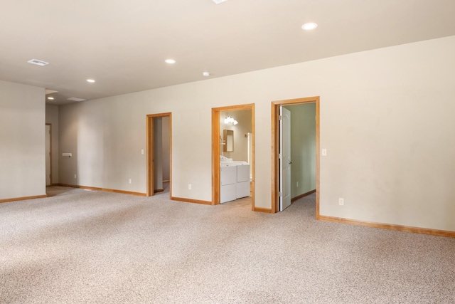 unfurnished room with baseboards, light carpet, washing machine and dryer, and recessed lighting