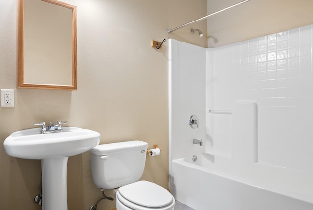 bathroom with a sink, bathtub / shower combination, and toilet
