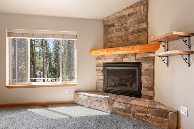 interior details with visible vents, carpet flooring, baseboards, and a stone fireplace