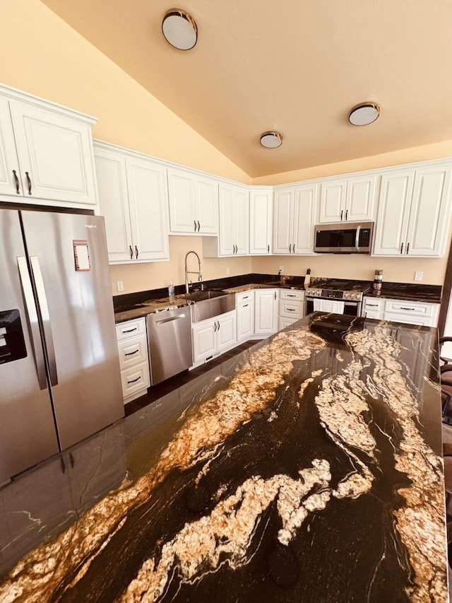 29 Shoreline Dr, Thompson Falls, MT 59873 - kitchen featuring appliances with stainless steel finishes, vaulted ceiling, a sink, white cabinetry, and dark stone counters