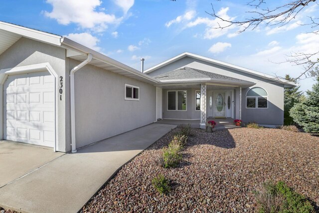2301 Larkspur Ln, Great Falls, MT 59404 - ranch-style home featuring a garage, stucco siding, covered porch, and concrete driveway