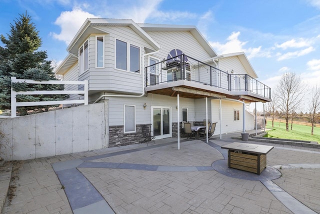 2301 Larkspur Ln, Great Falls, MT 59404 - back of property featuring a patio area, a balcony, and stone siding