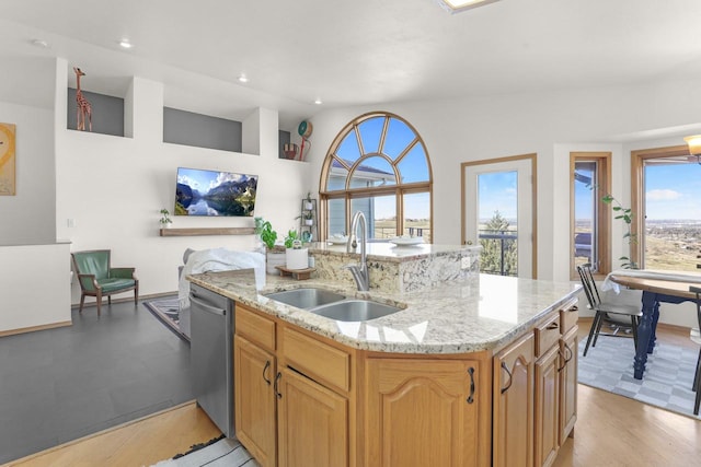 2301 Larkspur Ln, Great Falls, MT 59404 - kitchen featuring stainless steel dishwasher, a kitchen island with sink, light stone counters, a sink, and vaulted ceiling