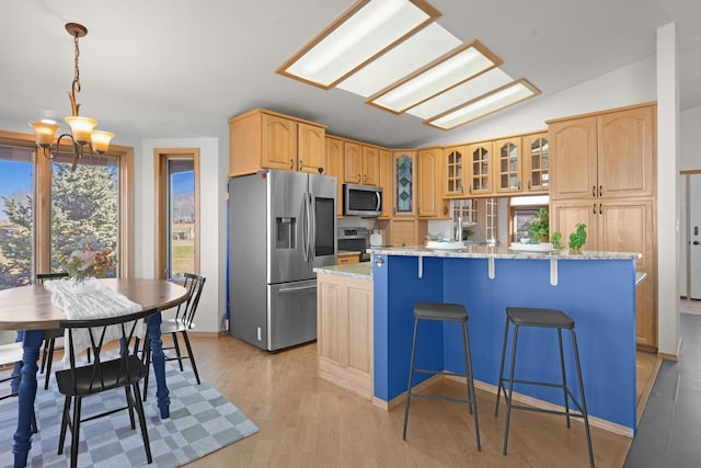 2301 Larkspur Ln, Great Falls, MT 59404 - kitchen featuring a kitchen island with sink, a notable chandelier, glass insert cabinets, stainless steel appliances, and light wood-style flooring